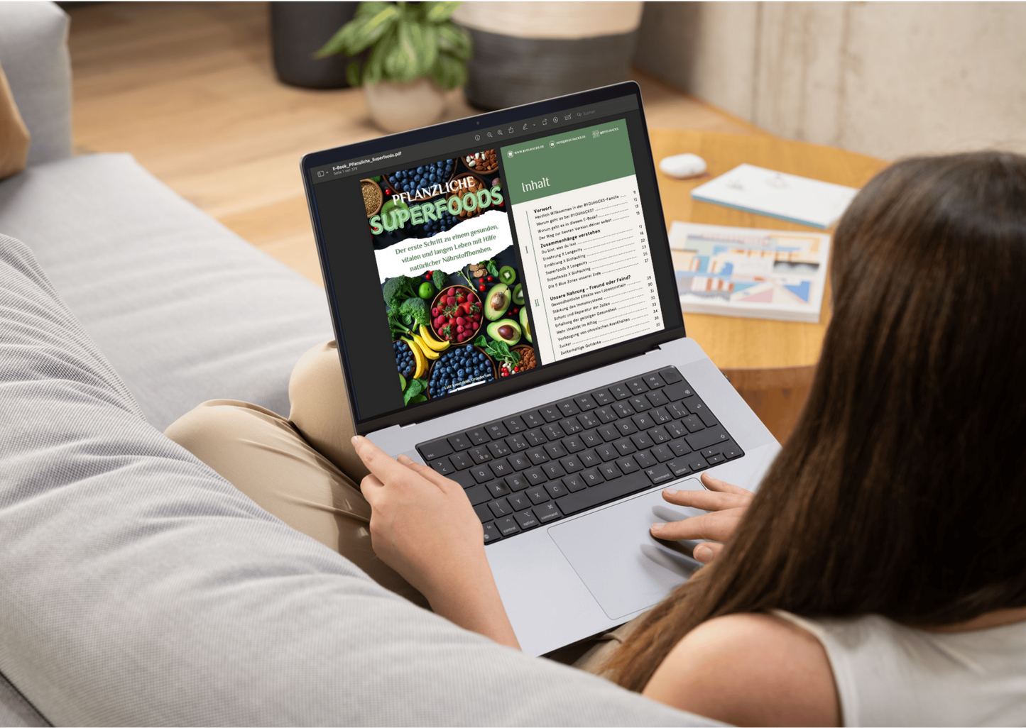 Frau liest auf dem Laptop die ersten Seiten aus dem E-Book "Pflanzliche Superfoods".