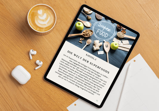 Das dritte Kapitel "Die Welt der Superfoods" aus dem E-Book "Pflanzliche Superfoods", dargestellt auf einem iPad. Mit auf dem Bild sind Kaffee und Airpods zu sehen.